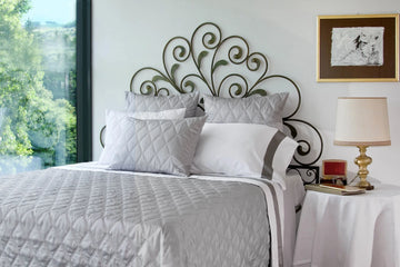 Signoria Filicudi Silver Moon bedding in bright room with decorative iron headboard.