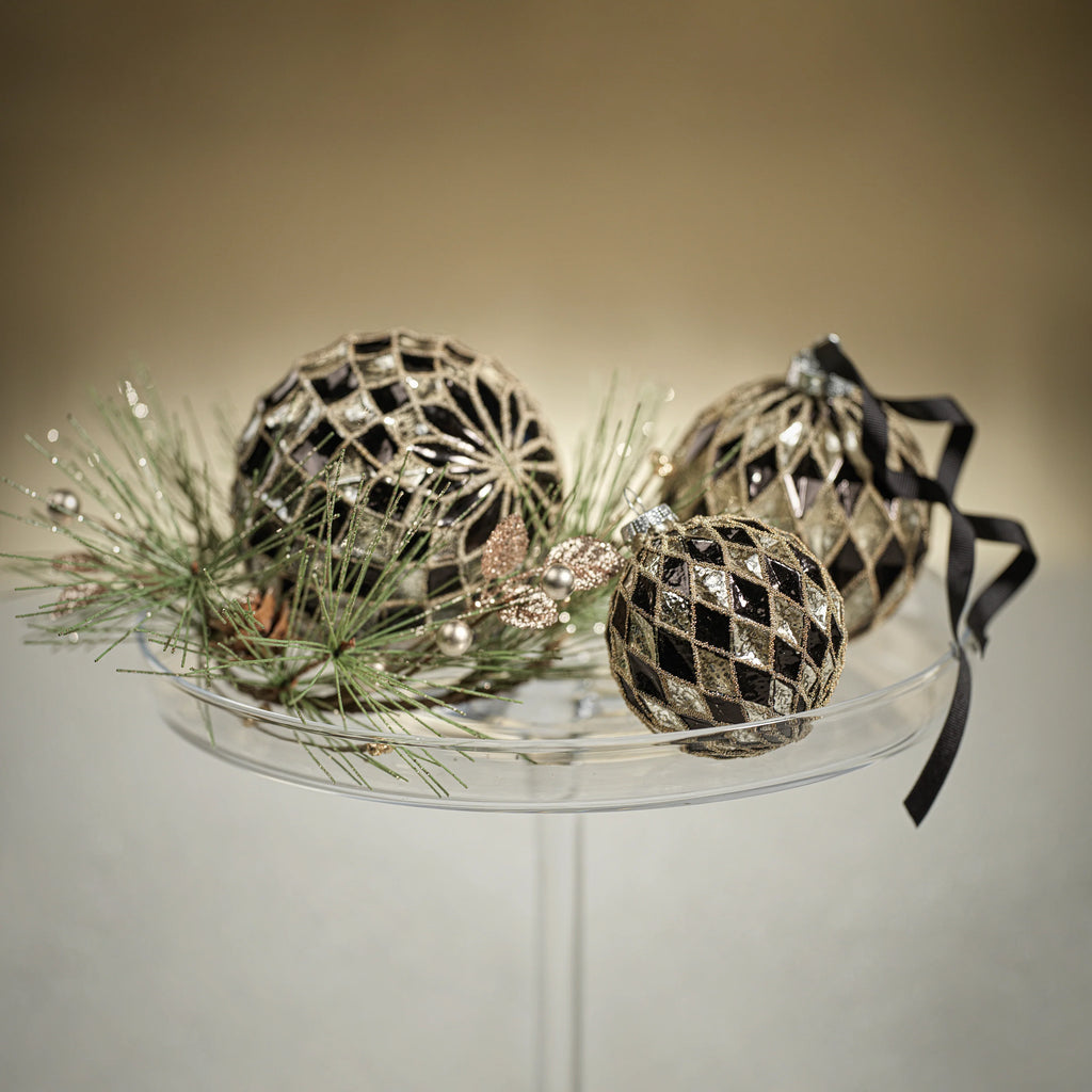 Harlequin Glass Ornaments - Silver and Black sitting on a glass tray 