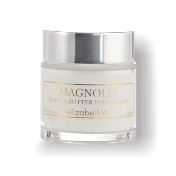 Elizabeth W Magnolia body cream in clear container with silver coloured lid and gold lettering.